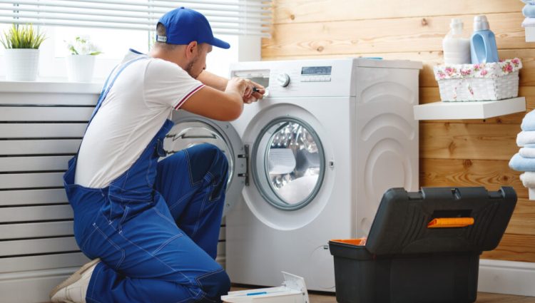 Working,Man,Plumber,Repairs,A,Washing,Machine,In,Laundry